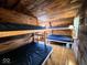 Rustic cabin interior with bunk beds featuring black vinyl mattresses, perfect for group stays in the woods at 3559 N Us Highway 41, Bloomingdale, IN 47832