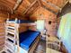 Inside cabin featuring wood paneled walls, bunk beds with a table, and yellow checkered curtains at 3559 N Us Highway 41, Bloomingdale, IN 47832