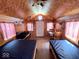 Cabin interior with beds, table, storage, and loft access with wood paneled walls and ceiling at 3559 N Us Highway 41, Bloomingdale, IN 47832