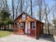 Quaint wood cabin featuring a porch, with a blue metal roof and a surrounding wooded area at 3559 N Us Highway 41, Bloomingdale, IN 47832