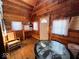 Cozy cabin interior features wood walls, a glass table, and rustic curtains, creating a warm atmosphere at 3559 N Us Highway 41, Bloomingdale, IN 47832