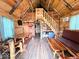 Spacious cabin interior with wood floors, rustic furniture, and a cozy staircase at 3559 N Us Highway 41, Bloomingdale, IN 47832