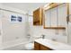This bright bathroom features a tub shower, a toilet, and a wooden vanity for storage and functionality at 3809 Wildwood Dr, Indianapolis, IN 46239