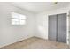 This simple bedroom features neutral carpet, freshly painted white walls, and a closet with sliding doors at 3809 Wildwood Dr, Indianapolis, IN 46239