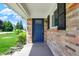 Inviting blue front door on a charming brick home with a well-manicured lawn and covered porch at 3809 Wildwood Dr, Indianapolis, IN 46239
