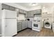 Well-lit kitchen with gray cabinets and appliances, including a laundry area at 3809 Wildwood Dr, Indianapolis, IN 46239