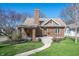 Charming brick home featuring a welcoming front porch, lush lawn, and beautiful landscaping at 4102 N Illinois St, Indianapolis, IN 46208