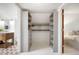 An organized walk-in closet leads to a well-lit bathroom with a tiled floor at 4102 N Illinois St, Indianapolis, IN 46208