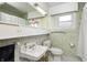 Classic bathroom featuring green tile, a vintage sink, and bright lighting for a clean, fresh feel at 438 N 11Th Ave, Beech Grove, IN 46107
