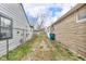 A backyard view showing the alleyway between the house and a stone wall at 4618 W Beecher St, Indianapolis, IN 46241