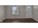 Open space with hardwood floors, a large window, and a white front door at 4618 W Beecher St, Indianapolis, IN 46241