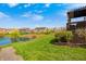 Landscaped backyard view featuring a pond, pergola covered deck and walking path at 4644 Shelby Cir, Greenwood, IN 46143