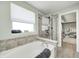 This bright bathroom offers a tub with shower, tile accents, and a window at 4644 Shelby Cir, Greenwood, IN 46143