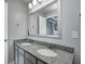 Double vanity bathroom with granite countertop and modern fixtures with a view into the hall at 4644 Shelby Cir, Greenwood, IN 46143