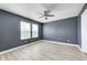 Empty bedroom showcasing wood floors, a ceiling fan, neutral gray walls, and natural lighting at 4644 Shelby Cir, Greenwood, IN 46143