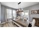 Bright dining area with a large wooden table, bench seating, and light filtering through large windows at 4644 Shelby Cir, Greenwood, IN 46143