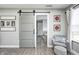 A hallway with a sliding barn door, a chair, and decor, offering a warm and inviting transition space at 4644 Shelby Cir, Greenwood, IN 46143