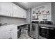 Modern laundry room equipped with new appliances, sink, gray subway tile backsplash, and decor at 4644 Shelby Cir, Greenwood, IN 46143