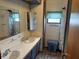 Bathroom featuring a double sink vanity, ample cabinet space, and a window at 4653 E Us Highway 36, Markleville, IN 46056