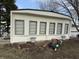 Side view of a manufactured home featuring white siding, gray shutters, and landscaping elements around the foundation at 4653 E Us Highway 36, Markleville, IN 46056