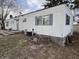 Exterior of a manufactured home showing the side with a utility area, steps to a door, and a brick firepit feature at 4653 E Us Highway 36, Markleville, IN 46056