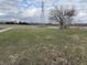 Expansive front yard with mature trees, utility pole, and a glimpse of a red barn at 4653 E Us Highway 36, Markleville, IN 46056