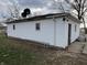 View of detached garage with white siding showing satellite dishes, security lights and ladder at 4653 E Us Highway 36, Markleville, IN 46056