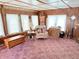 Bright living room with vintage decor, wood paneling, and ample natural light through large windows at 4653 E Us Highway 36, Markleville, IN 46056