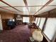 Inviting living room with brick fireplace, wood paneling, and large windows for natural light at 4653 E Us Highway 36, Markleville, IN 46056