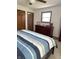 Cozy bedroom with a striped bedspread, wood dresser, and bright window at 4902 N 700 W, McCordsville, IN 46055