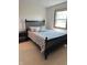 Comfortable bedroom with a dark bed frame, patterned bedding, and window at 4902 N 700 W, McCordsville, IN 46055