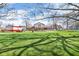 Expansive backyard featuring a lush lawn, a red barn, and a brick home with Tudor accents at 4930 Founders Ct, Anderson, IN 46017