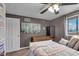Cozy bedroom featuring a ceiling fan, mini-refrigerator, and ample natural light from the window at 4930 Founders Ct, Anderson, IN 46017