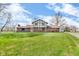 Charming two-story home with brick facade and expansive green lawn under a partly cloudy sky at 4930 Founders Ct, Anderson, IN 46017