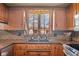 Well-lit kitchen featuring wood cabinets, stainless steel appliances, a farmhouse sink, and granite countertops at 4930 Founders Ct, Anderson, IN 46017