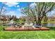 Scenic backyard showcasing a spacious deck with comfortable seating beside a serene pond with a fountain at 4932 Willow Ridge Ct, Zionsville, IN 46077