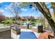 Charming backyard deck furnished with comfortable seating and a fire pit, set against a picturesque pond backdrop at 4932 Willow Ridge Ct, Zionsville, IN 46077