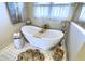 Close up of the bathroom featuring a freestanding tub, with a wood caddy, and a decorative tiled floor at 4932 Willow Ridge Ct, Zionsville, IN 46077