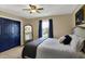Well-lit bedroom with a comfortable bed, ceiling fan, blue closet doors, and large mirror at 4932 Willow Ridge Ct, Zionsville, IN 46077
