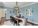 Dining room with modern chandelier, seating for eight, and large artwork at 4932 Willow Ridge Ct, Zionsville, IN 46077