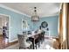 Elegant dining room with stylish lighting, seating for eight, and serene blue walls at 4932 Willow Ridge Ct, Zionsville, IN 46077