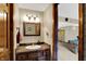 Charming powder room with stylish wallpaper, granite countertop and a wood framed mirror at 4932 Willow Ridge Ct, Zionsville, IN 46077