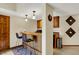 Charming wet bar featuring wood paneling, a granite countertop, pendant lights and a beverage center at 4932 Willow Ridge Ct, Zionsville, IN 46077