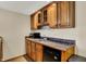 This cozy wet bar features wood cabinets, granite countertops, and a mini fridge perfect for entertaining at 4932 Willow Ridge Ct, Zionsville, IN 46077