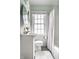 Bright bathroom with a white sink, toilet, and vanity, complemented by a large window with natural light at 5140 Indianola Ave, Indianapolis, IN 46205