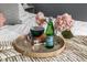 Close up of decor including flowers and Pellegrino water on a tray on top of a bed with throw blanket and pillows at 5140 Indianola Ave, Indianapolis, IN 46205