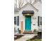 Charming home featuring a bright teal front door, landscaped yard, and welcoming signage at 5140 Indianola Ave, Indianapolis, IN 46205