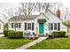 Charming home featuring a bright teal front door, landscaped yard, and cozy seating area on the front porch at 5140 Indianola Ave, Indianapolis, IN 46205