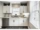 Modern kitchen featuring stainless steel appliances, granite countertops, and white cabinetry with a window view at 5140 Indianola Ave, Indianapolis, IN 46205