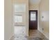 Home entryway featuring a door with decorative glass and an open doorway to a room with a large window at 5213 Milhouse Rd, Indianapolis, IN 46221